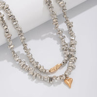 Colar retrô com pingente em formato de coração.